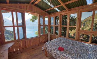 a wooden house with a large window overlooking a body of water , possibly a lake at Eagle's Retreats