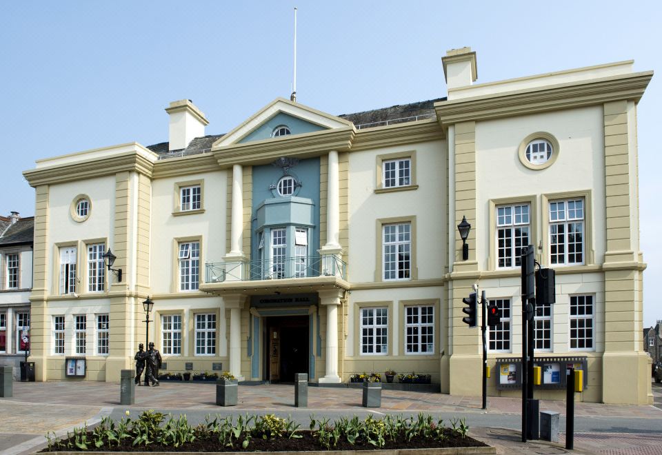 a large white building with a blue facade and two windows is shown in the image at Premier Inn Ulverston