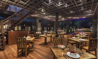 a large dining room with wooden tables and chairs arranged for a group of people to enjoy a meal at Coconut Boutique Resort