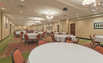 a large , well - lit banquet hall with multiple round tables and chairs arranged for a formal event at Holiday Inn Birmingham - Hoover