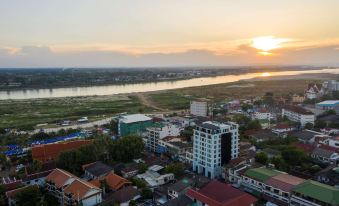 aerial view of a city at sunset , with a river running through the city and buildings in the background at SureStay Hotel by Best Western Vientiane