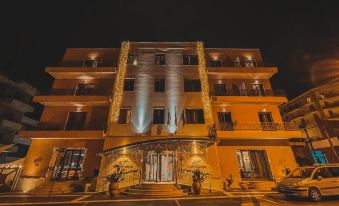 a nighttime scene of a building with multiple lights illuminating it and creating a festive atmosphere at Panorama Hotel