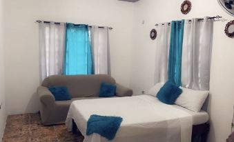 a bed with blue pillows and a white comforter is in front of two blue curtains at Diamonds