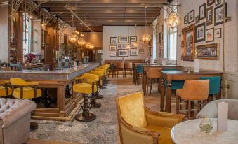 a modern , minimalist restaurant interior with wooden beams and stone floors , featuring yellow chairs and wooden tables at De Vere Beaumont Estate