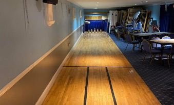 a long , narrow room with a bowling alley on one side and a dining area on the other at The Old Pound Inn