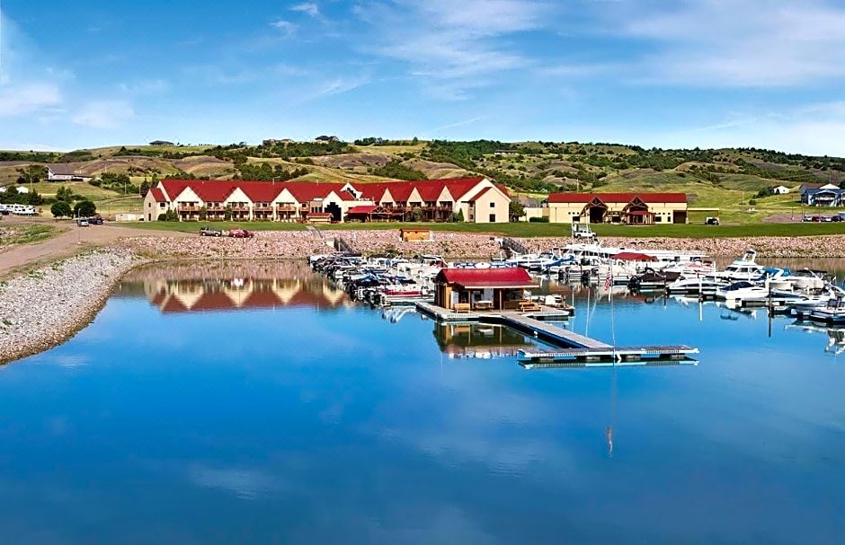 a marina with several boats docked , surrounded by a picturesque lake and mountainous landscape at Arrowwood Resort at Cedar Shore