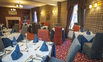 a dining room with tables and chairs arranged for a group of people to enjoy a meal together at Loch Kinord Hotel