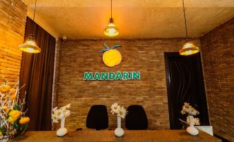 a reception area with a large orange sign and two white vases on either side of a desk at Mandarin