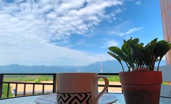 a cup of coffee is sitting on a table with a view of the ocean in the background at The Sunnery Ville