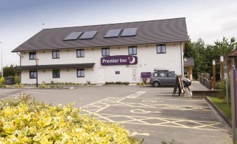"a white hotel building with the name "" premier inn "" prominently displayed on its sign , surrounded by cars and people in a parking lot" at Premier Inn Tamworth South
