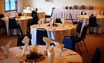 a dining room with round tables and chairs arranged for a formal event , possibly a wedding reception at Scandinavian Lodge