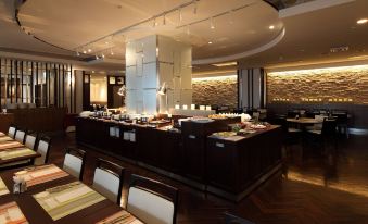 a dining area with a long wooden table and chairs , as well as a buffet table filled with various food items at Kichijoji Tokyu Rei Hotel