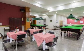 a large room with tables and chairs , and a pool table in the background at Sakol Hotel