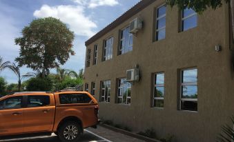 a brown truck is parked next to a building with multiple windows , under a clear blue sky at Parkview Hotel