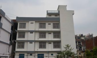 a tall , white building with a blue sign on the side , located in a residential area at The Village