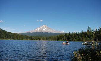a group of people , including a man and a woman , are canoeing on a lake near a snow - capped mountain at Hampton Inn Portland East