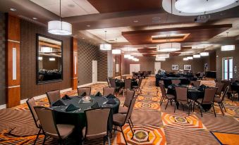 a large , well - lit restaurant with multiple dining tables and chairs arranged in a restaurant setting at SpringHill Suites Deadwood
