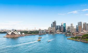 a city skyline with boats on the water and boats in the foreground , creating a picturesque scene at The Urban Newtown