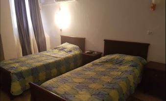 a hotel room with two beds , one on the left and one on the right side of the room at Hotel Antar