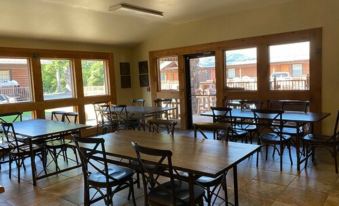 a large room with multiple tables and chairs arranged for a group of people to sit and eat at New Hochatown Lodge