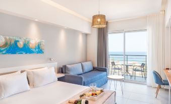 a modern hotel room with a large window offering an ocean view , a comfortable bed , and a dining table at Atali Grand Resort