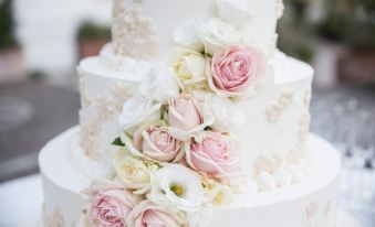 a white wedding cake decorated with pink and white roses , creating a romantic and elegant atmosphere at The Westin Chicago North Shore