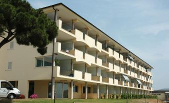 a modern apartment building with multiple balconies and balconies , situated in a sunny location near trees at Smeraldo