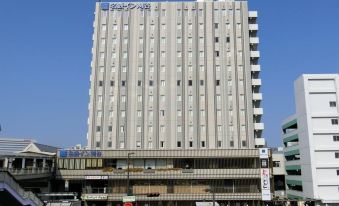 "a tall , white building with the words "" crystal "" on its side , surrounded by other buildings and people" at Meitetsu Inn Kariya