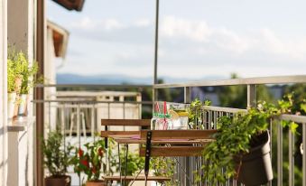 a balcony with a table and chairs , potted plants , and a view of the city at Garden Apartment