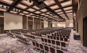 a large conference room with rows of chairs arranged in a semicircle , and a podium at the front of the room at Lotte Hotel Yangon