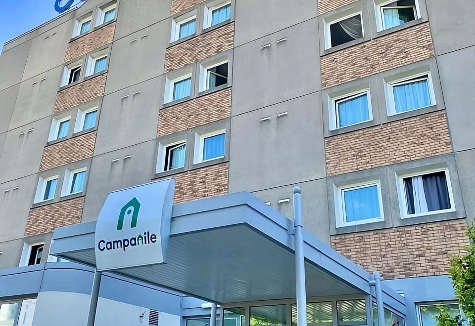 "a tall hotel building with a sign that reads "" campia "" prominently displayed on the front" at Campanile Paris Est - Bobigny