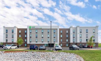 There is a large building with cars parked in front and an empty parking lot next to it at Extended Stay America Suites - Huntsville - Madison