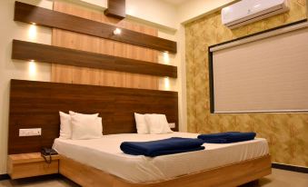 a bed with a wooden headboard and two blue towels on top of it is in a room at Angel Hotels