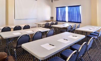 a classroom with desks and chairs arranged in rows , ready for a class to begin at The Classic Desert Aire Hotel