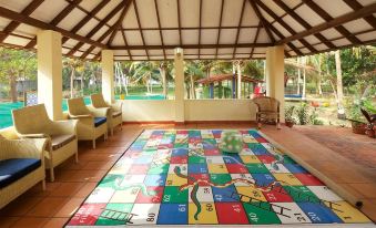 a large , colorful rug with a snakes and ladders design is displayed in a room with chairs at Poovar Island Resort