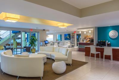 a modern hotel lobby with white couches and chairs , creating a comfortable and inviting atmosphere at Wyndham Reef Resort Grand Cayman