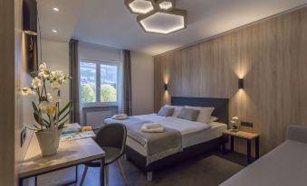 a modern hotel room with a large bed , a desk , a chair , and a window at Tourist Hotel