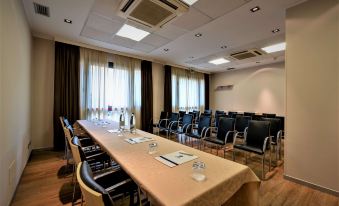 a large conference room with a long table and multiple chairs arranged for a meeting at Best Western Palace Inn Hotel