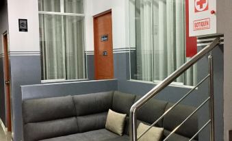 a modern living room with a gray couch and a stainless steel railing on the stairs at Hotel Marbella