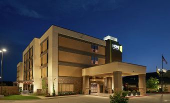 a large hotel building with a parking lot in front of it at night , illuminated by the lights of the lights at Home 2 Suites by Hilton Muskogee