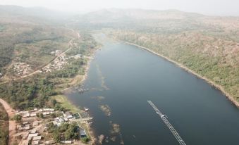 a bird 's eye view of a river with houses and boats on the water , surrounded by mountains at The Float