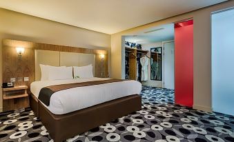 a modern hotel room with a large bed , black and white patterned carpet , and an open door leading to another room at Holiday Inn Sittingbourne