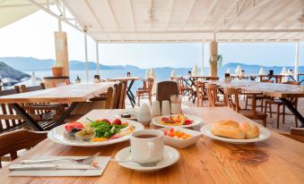 a dining table with a variety of food and drinks , including plates , cups , and bowls at Aquarius Hotel