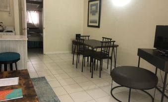 a dining room with a table and chairs , a couch , and a doorway leading to another room at Regent Apartments