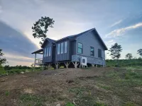 Small cottage house, centered on 100 acres surround by hills, lake, and cattle.