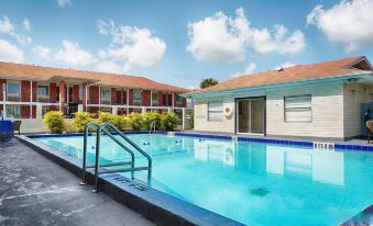 a large swimming pool with a building in the background and a metal ladder leading into it at Best Western Space Shuttle Inn