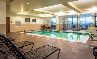 an indoor swimming pool surrounded by lounge chairs , with a view of the ocean in the background at Hilton Garden Inn Uniontown