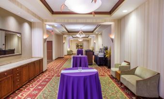 a room with tables covered in purple tablecloths and chairs arranged in rows , creating an event space at Sonesta Milwaukee West Wauwatosa
