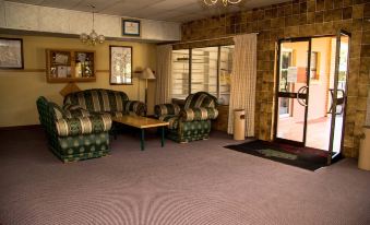 a living room with two couches , a coffee table , and a door leading to the outside at The Palace Hotel