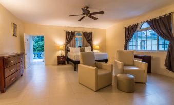 a spacious living room with a couch , chairs , and a tv . the room is well - appointed and spacious at Travellers Beach Resort
